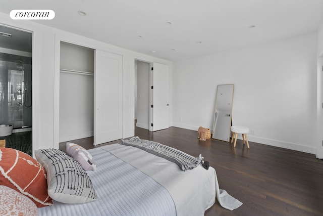 bedroom with baseboards, a closet, wood finished floors, and visible vents