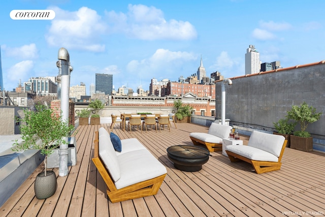 wooden deck featuring outdoor dining area and a city view