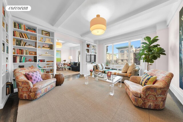 sitting room featuring built in shelves, visible vents, and beamed ceiling