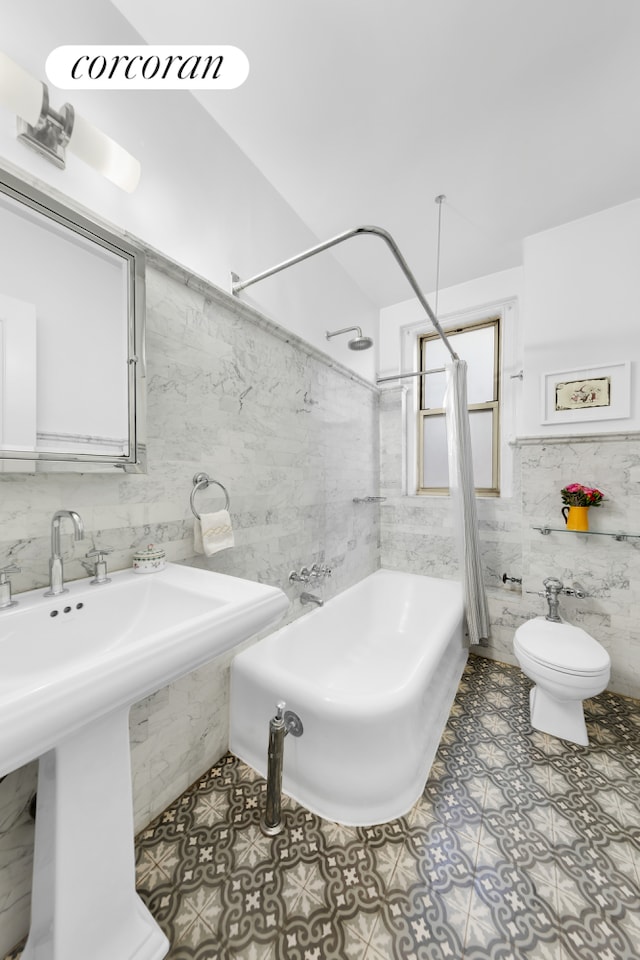 full bathroom with a sink, toilet, shower / tub combination, and tile walls