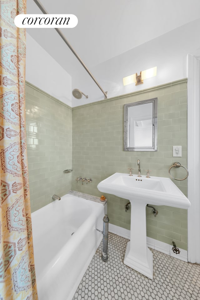 bathroom with tile walls, shower / tub combo with curtain, and tile patterned floors