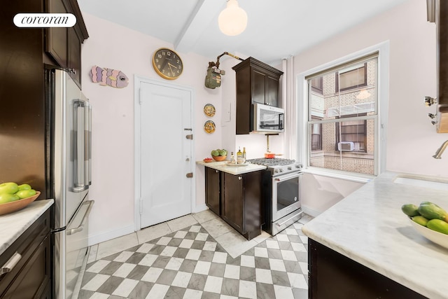 kitchen with stainless steel appliances, light countertops, a sink, and dark brown cabinets