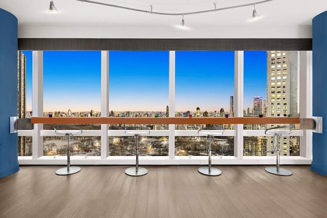 unfurnished sunroom with a view of city and rail lighting