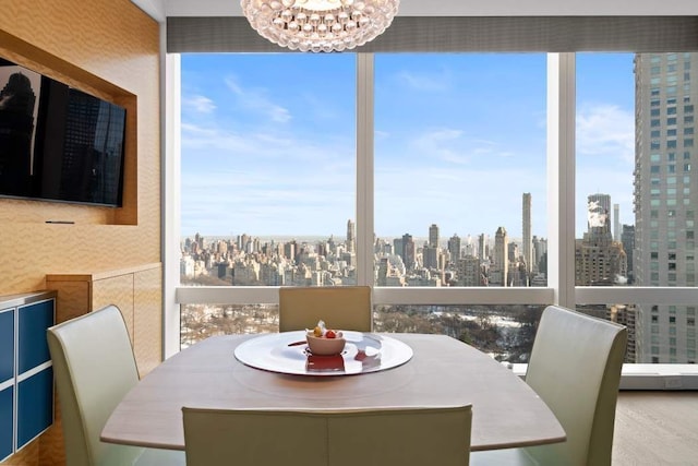 dining area with wallpapered walls, a notable chandelier, and a city view