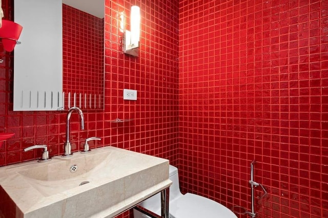 half bathroom with toilet, tile walls, vanity, and backsplash