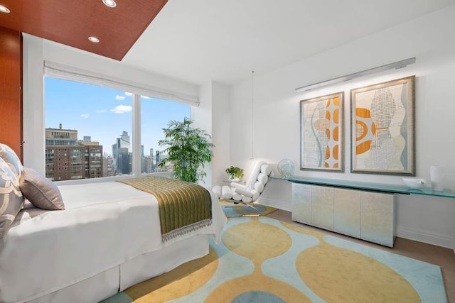 bedroom with recessed lighting, baseboards, and a view of city