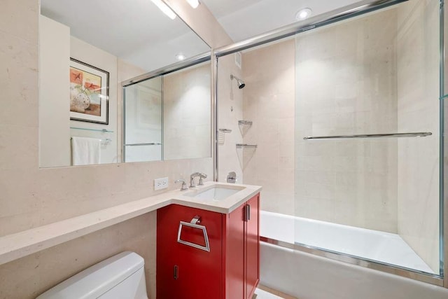bathroom featuring toilet, bath / shower combo with glass door, vanity, and recessed lighting