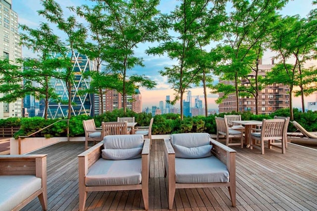 wooden deck featuring a skyline view and outdoor dining space