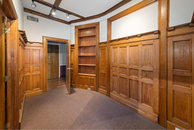 interior space with carpet floors, rail lighting, visible vents, and built in features