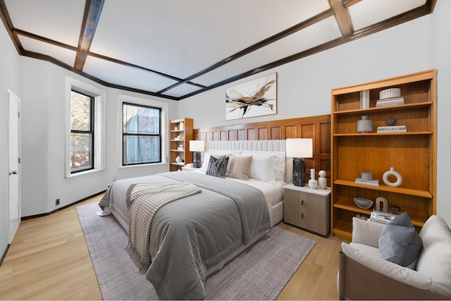 bedroom featuring light wood-style floors, ornamental molding, and baseboards