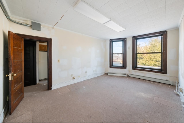 carpeted empty room with ornamental molding, a baseboard radiator, and baseboards