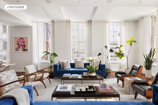 living area featuring baseboards, visible vents, and wood finished floors