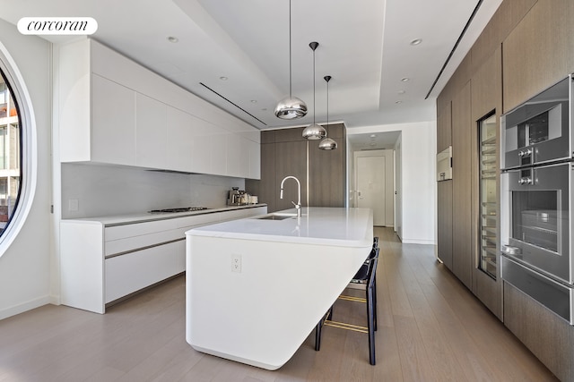 520 W 28th St Unit 29, New York City, NY 10001 - kitchen with modern cabinets, a warming drawer, light countertops, light wood-style floors, and recessed lighting