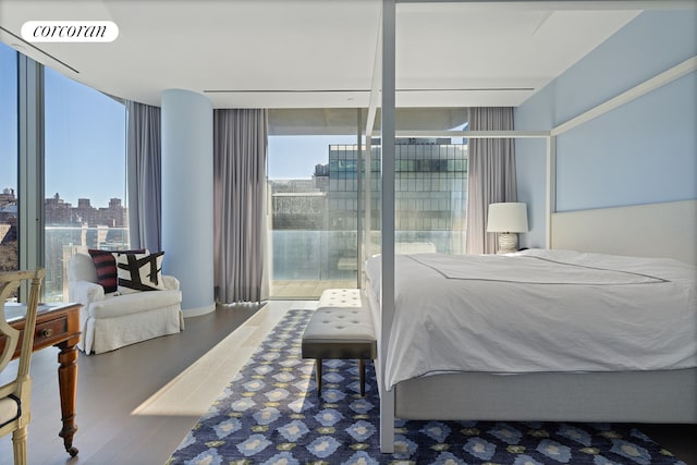 520 W 28th St Unit 29, New York City, NY 10001 - bedroom featuring expansive windows, wood finished floors, multiple windows, a city view, and access to exterior
