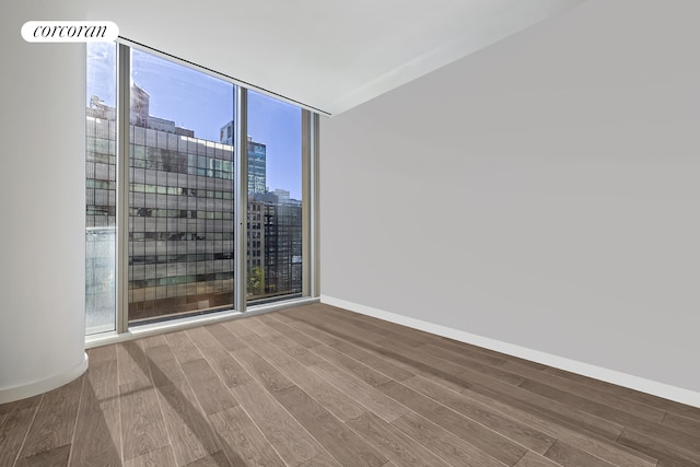 520 W 28th St Unit 29, New York City, NY 10001 - spare room with wood finished floors, a view of city, and floor to ceiling windows