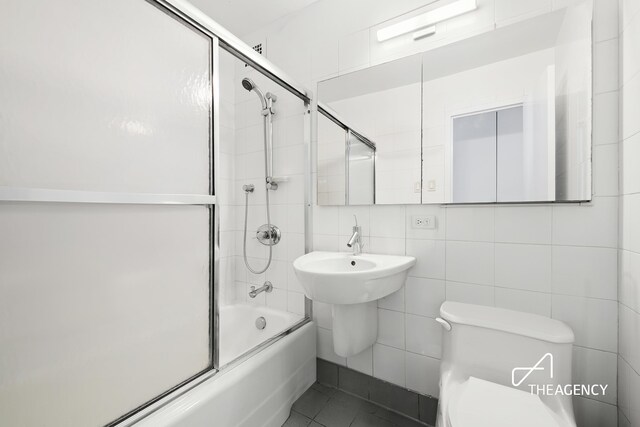 170 Park Row Unit 7C, New York City, NY 10038 - bathroom with enclosed tub / shower combo, toilet, tile walls, and tasteful backsplash