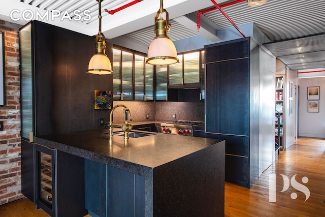 kitchen with dark countertops, range, wood finished floors, and a sink