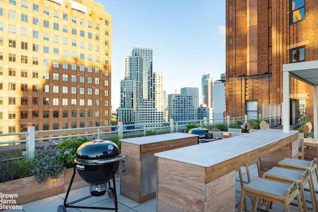 view of patio / terrace featuring a city view, a grill, and outdoor dry bar