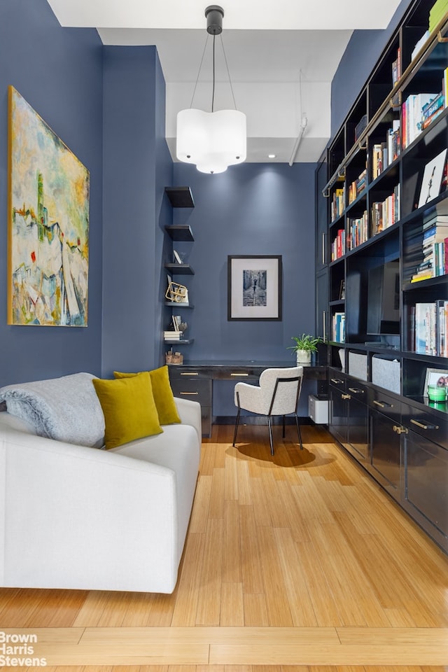 living area featuring a towering ceiling and wood finished floors