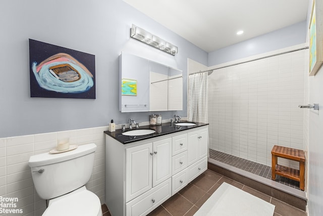 full bath featuring tiled shower, a sink, toilet, and tile patterned floors