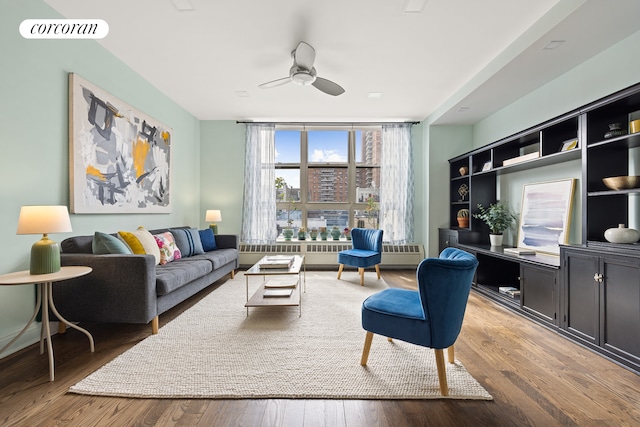 living room featuring visible vents, ceiling fan, radiator heating unit, and wood finished floors