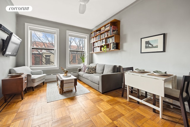 living area with visible vents, baseboard heating, and ceiling fan