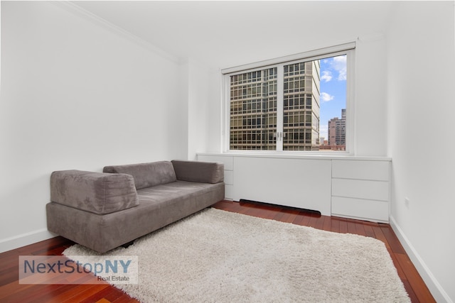 living area featuring baseboards, a view of city, ornamental molding, and dark wood-type flooring