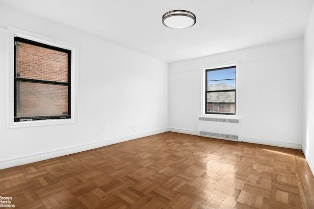 empty room with radiator heating unit and baseboards