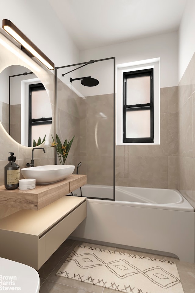 bathroom featuring toilet, vanity, tile walls, tile patterned floors, and washtub / shower combination