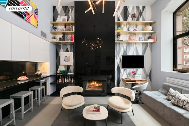 living room with visible vents, a large fireplace, and a towering ceiling