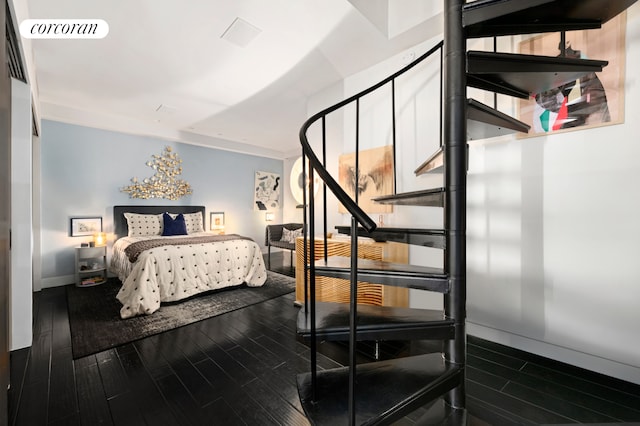 bedroom with baseboards, visible vents, and dark wood finished floors