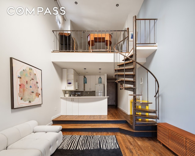 211 Thompson St Unit Ph6D, New York City, NY 10012 - living area with wood finished floors, stairway, and a high ceiling