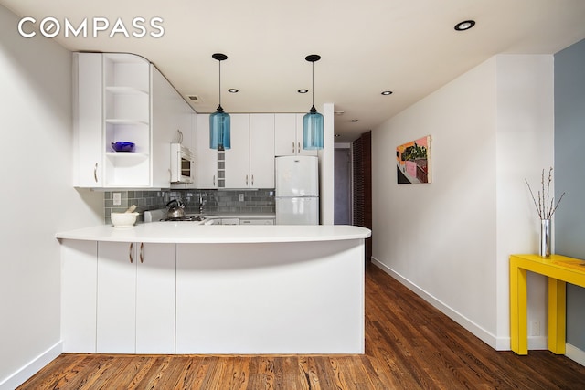 kitchen featuring white appliances, decorative backsplash, a peninsula, light countertops, and open shelves