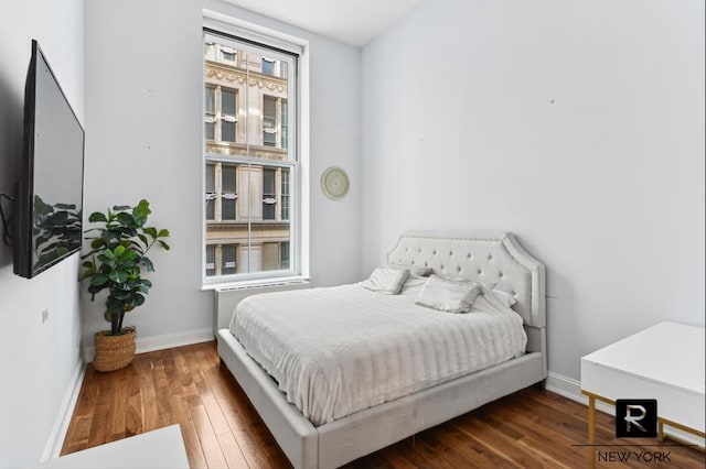 bedroom with baseboards and dark wood-style flooring