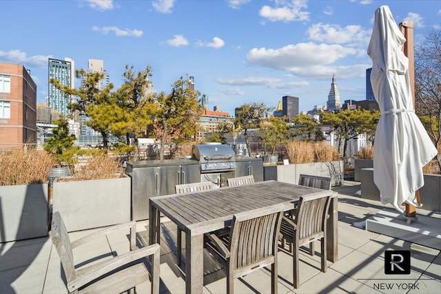 view of patio featuring area for grilling, a city view, and outdoor dining space