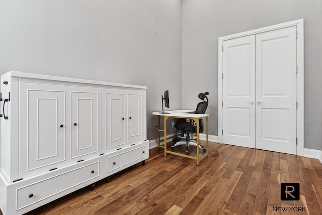 office space with baseboards and wood finished floors