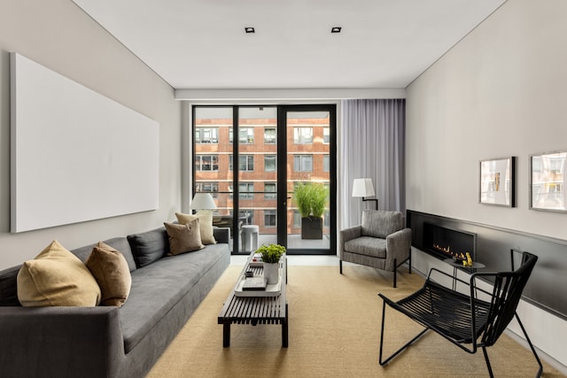 sitting room featuring light carpet and a lit fireplace