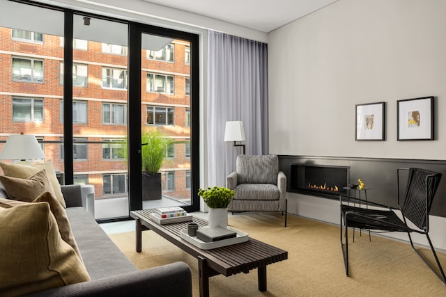 living area featuring light colored carpet and a lit fireplace