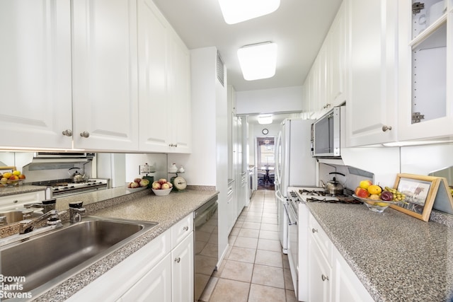 kitchen featuring dishwasher, white gas range oven, a sink, and white cabinets