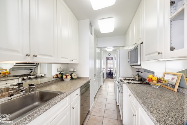 kitchen with visible vents, a sink, light tile patterned floors, white cabinets, and stainless steel appliances
