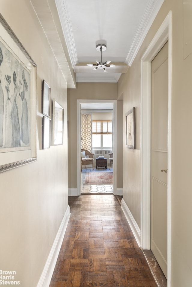 hallway featuring baseboards, a notable chandelier, and ornamental molding