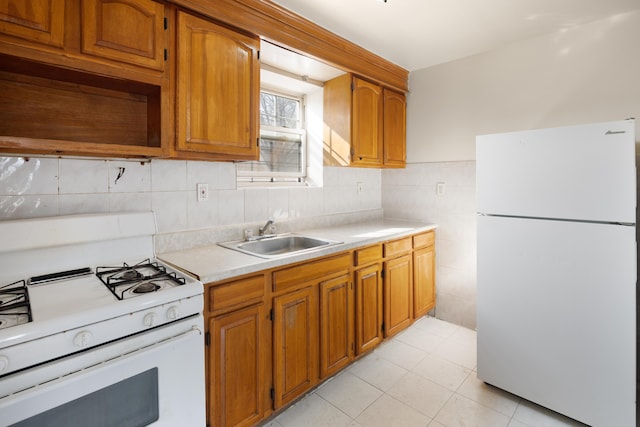 kitchen featuring white appliances, light tile patterned floors, brown cabinets, light countertops, and a sink