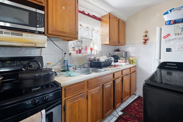 kitchen featuring light tile patterned floors, black / electric stove, a sink, range, and stainless steel microwave