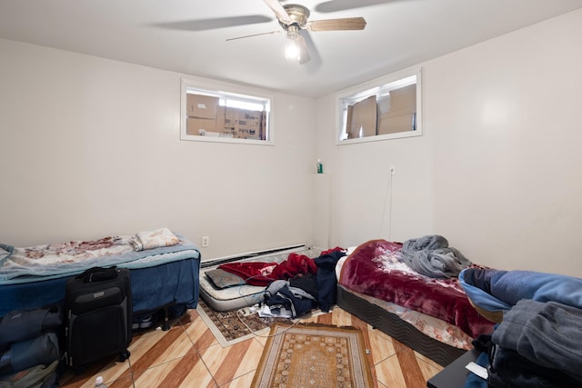 bedroom with light tile patterned floors, a baseboard heating unit, and a ceiling fan