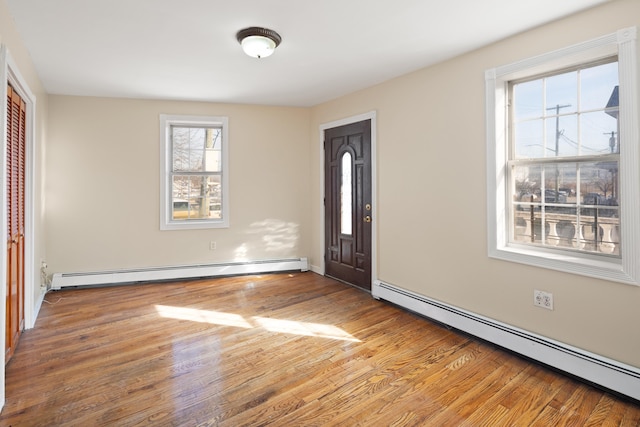 entryway with a baseboard heating unit and wood finished floors