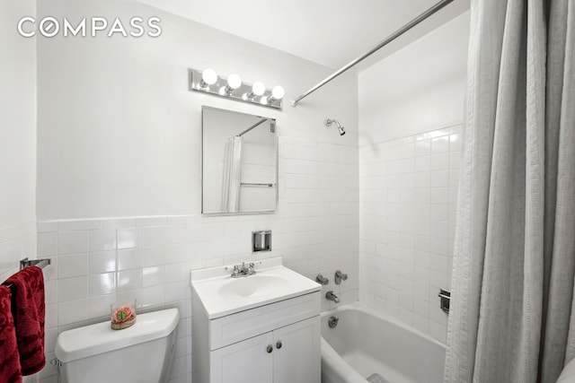 full bath with toilet, shower / tub combo, tile walls, and vanity