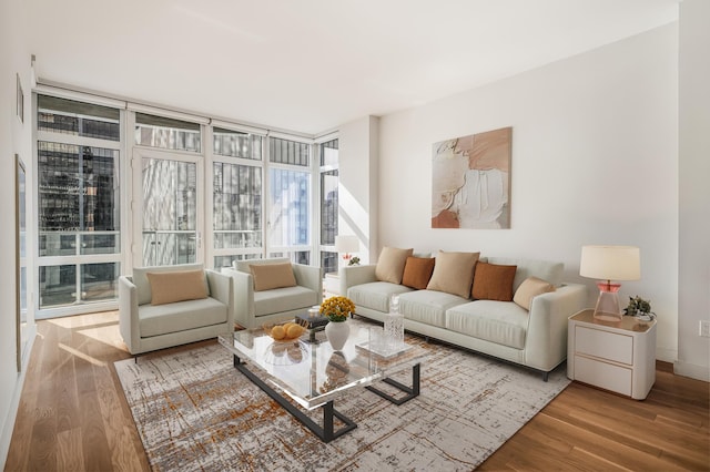 living area with floor to ceiling windows and wood finished floors