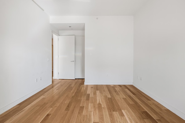 spare room with light wood finished floors and baseboards