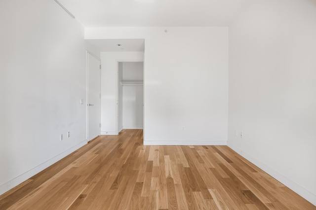 empty room featuring light wood-type flooring and baseboards