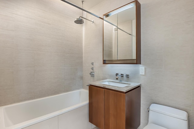 full bathroom featuring toilet, shower / washtub combination, vanity, and tile walls